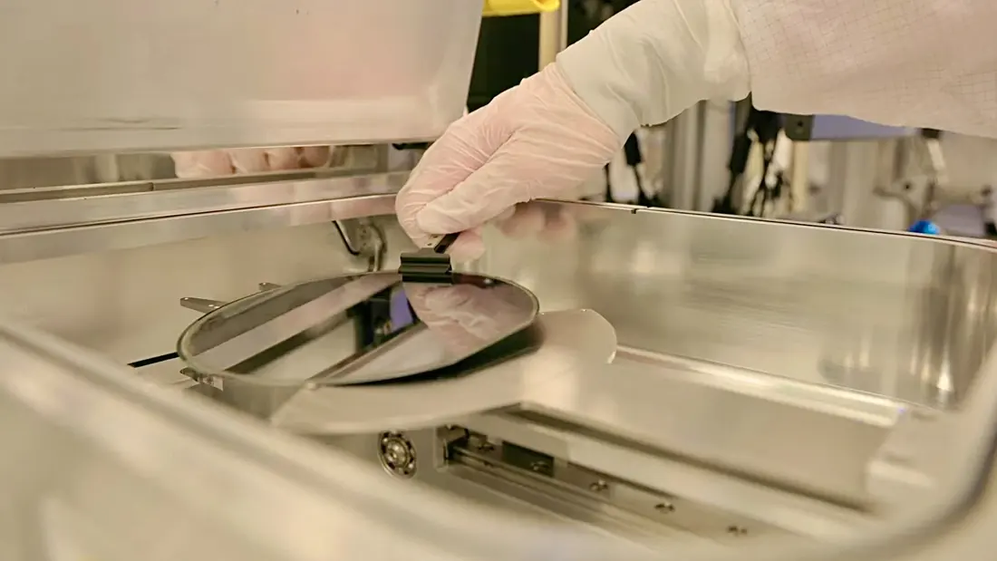 A semiconductor wafer being lifted from processing equipment