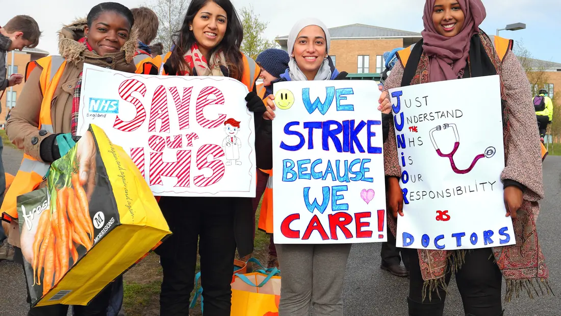Junior doctors in white coats outside a hospital entrance